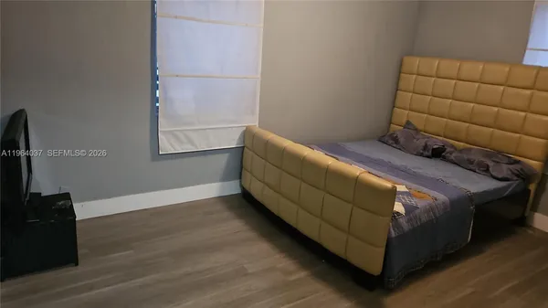 a bed sitting in a bedroom next to a window