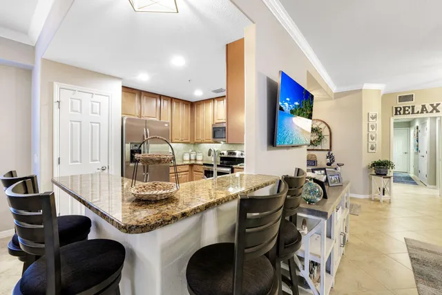 a kitchen with granite countertop a sink and a stove top oven with wooden floor