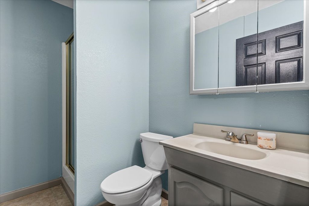 650 West Austin Street Luling, TX 78648 - Photo 14 of 18 A well-maintained bathroom with a sleek vanity and a shower with a sliding glass door.