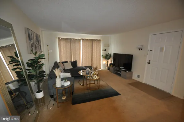 a living room with furniture a flat screen tv and a window