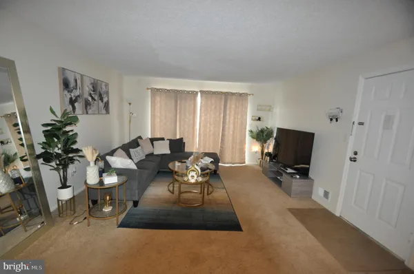 a living room with furniture a flat screen tv and a window
