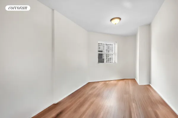 a view of a big room with wooden floor and windows