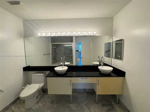 a view of an empty room with wooden floor and windows