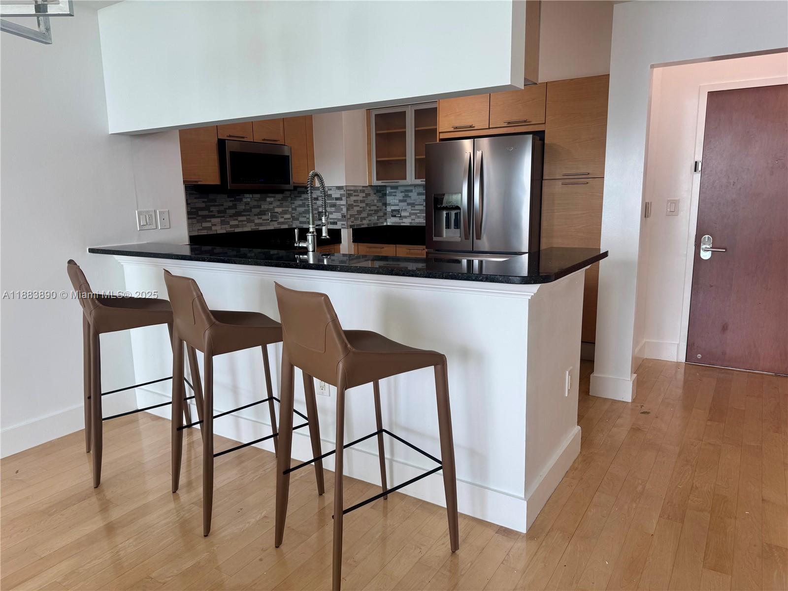 31 Southeast 5th Street, Unit 3817 Miami, FL 33131 - Photo 5 of 26 a kitchen with stainless steel appliances granite countertop a refrigerator and microwave
