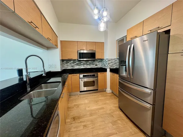 a kitchen with stainless steel appliances granite countertop a refrigerator and a stove top oven