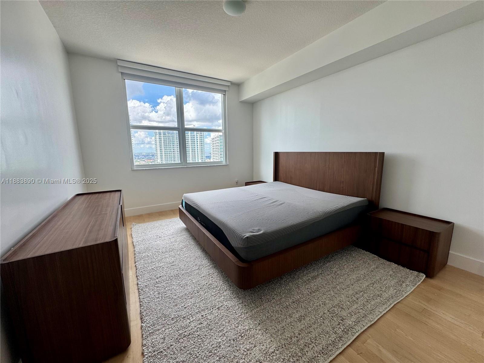 31 Southeast 5th Street, Unit 3817 Miami, FL 33131 - Photo 10 of 26 a bedroom with a bed lamp and window