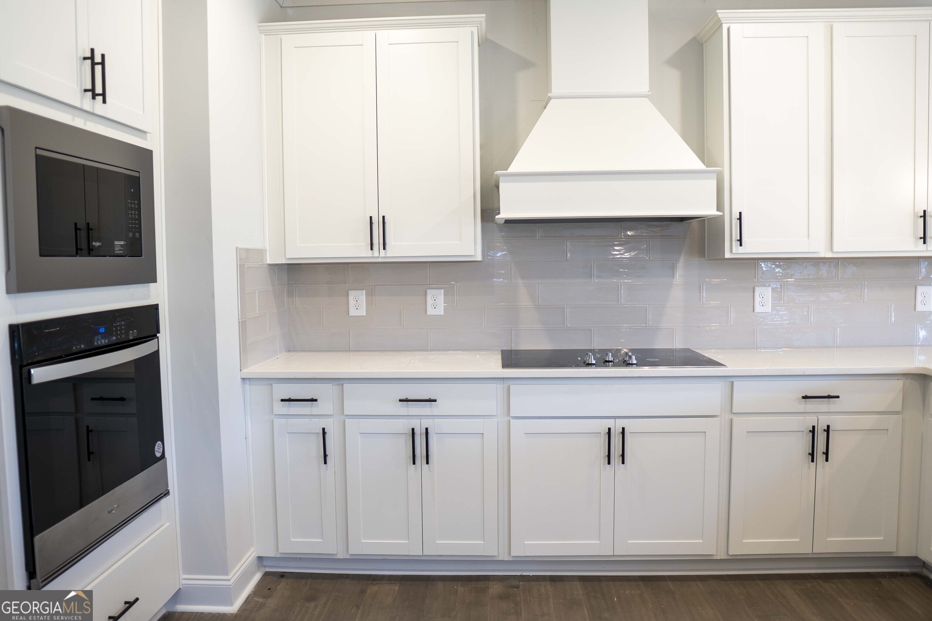 600 Beaver Court Perry, GA 31069 - Photo 17 of 48 a kitchen with white cabinets and a stove with wooden floor