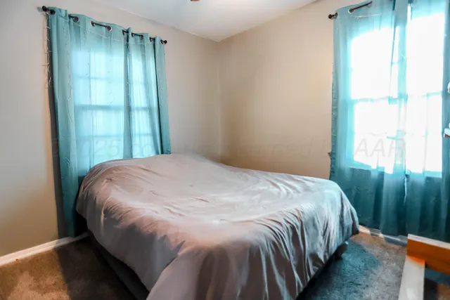 a bed sitting in a bedroom next to a window