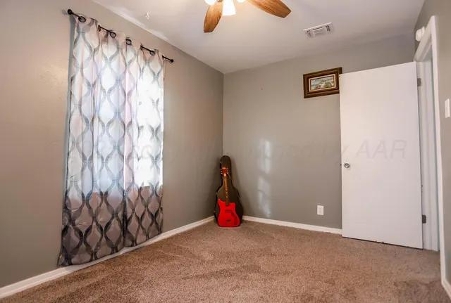 a view of a room with window chandelier fan and refrigerator