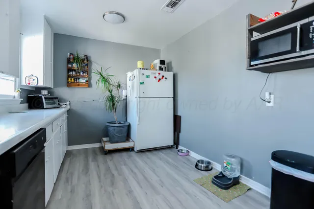 a kitchen with a refrigerator and a stove top oven