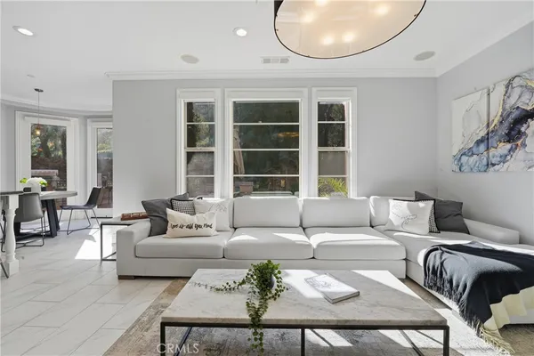 a kitchen with stainless steel appliances granite countertop a refrigerator a sink a stove a dining table and chairs