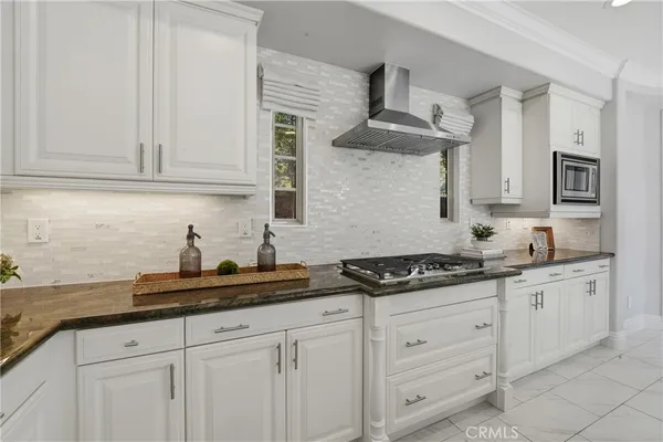 a kitchen with stainless steel appliances granite countertop a sink a stove and a refrigerator