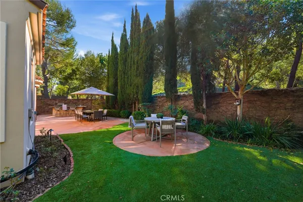 a view of patio with chairs and table under an umbrella