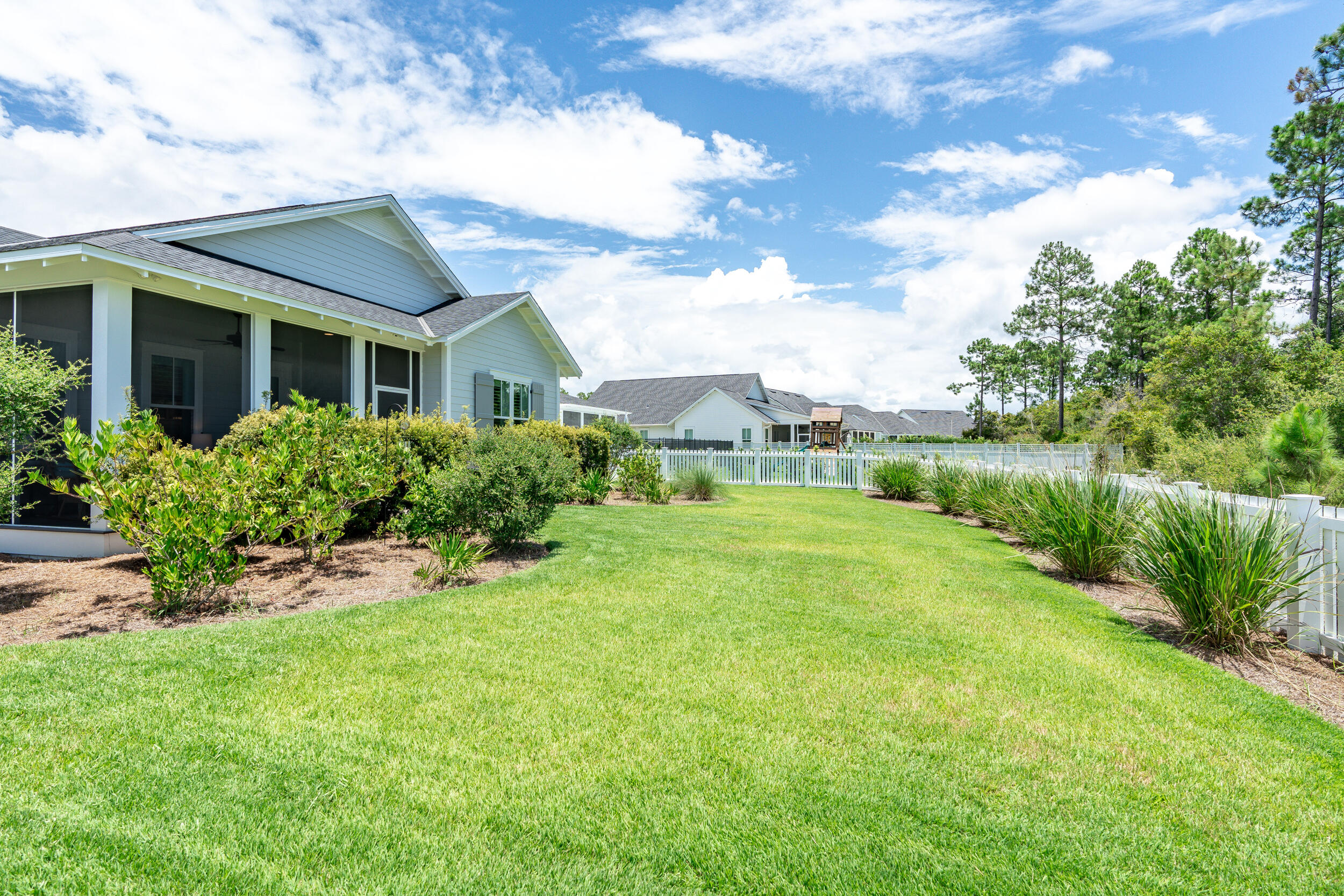 170 Sidecamp Road, Unit LOT 85 Watersound, FL 32461 - Photo 42 of 54 a view of a house with a big yard potted plants and a large tree