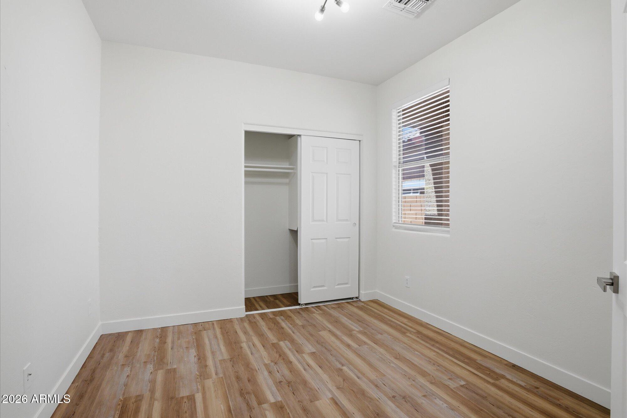 8838 West Payson Road Tolleson, AZ 85353 - Photo 16 of 22 a view of empty room with wooden floor and fan