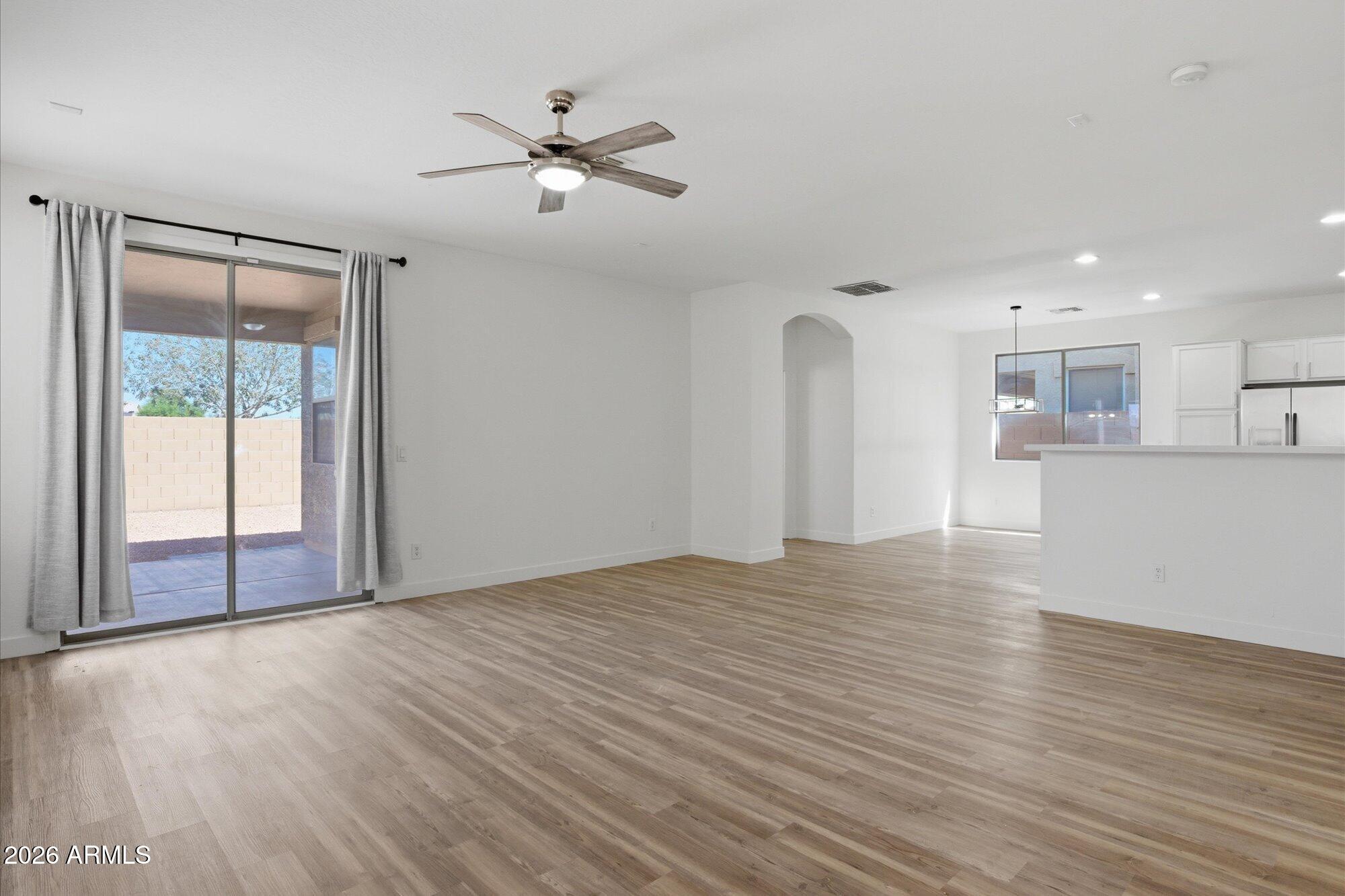 8838 West Payson Road Tolleson, AZ 85353 - Photo 3 of 22 a view of an empty room with wooden floor and a window