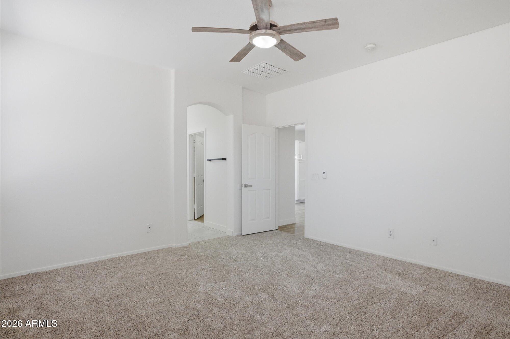 8838 West Payson Road Tolleson, AZ 85353 - Photo 10 of 22 an empty room with a ceiling fan and a window