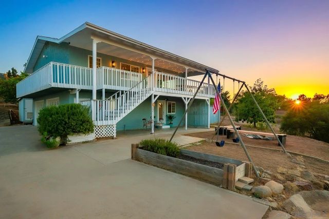 a aerial view of a house with a yard and lake view