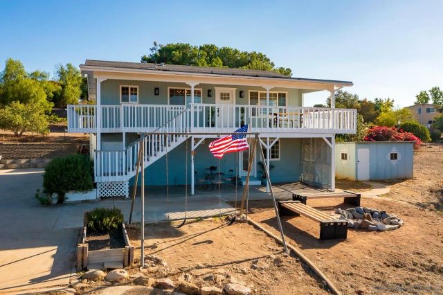 a view of a house with pool and wooden fence