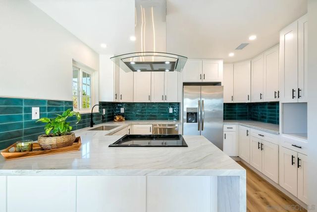 a kitchen with granite countertop a white cabinets and refrigerator