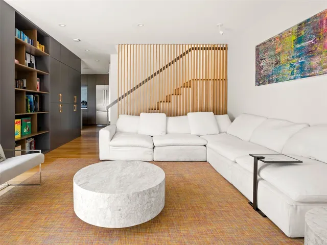 a living room with furniture and a book shelf