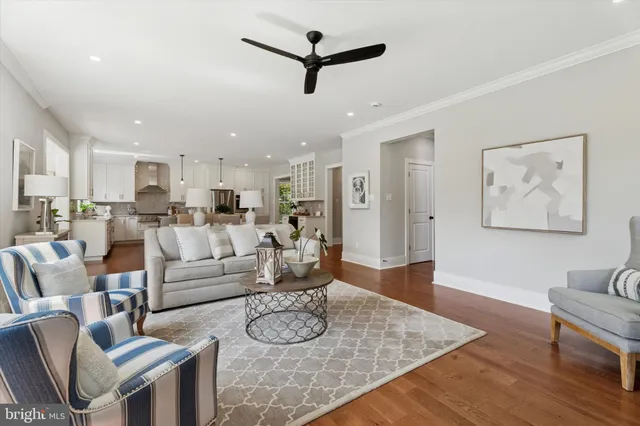 a living room with furniture kitchen view and a chandelier