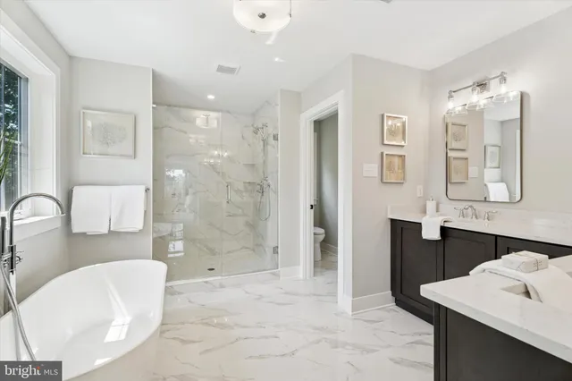a bathroom with a tub sink and mirror