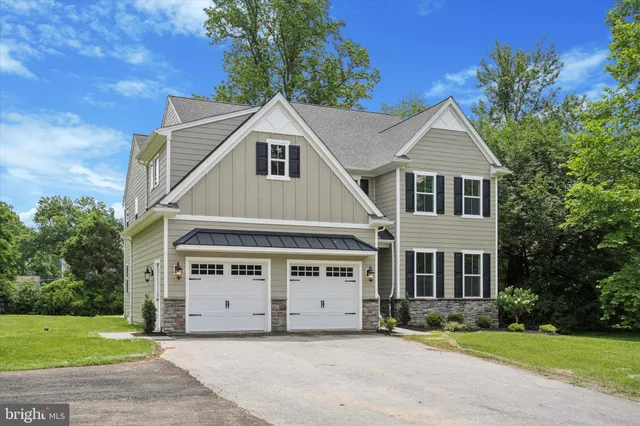 a view of a white house with a big yard and large trees