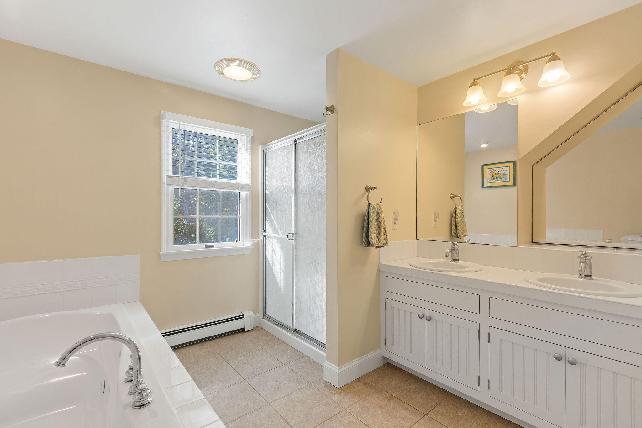 274 Commons Way Brewster, MA 02631 - Photo 16 of 32 a spacious bathroom with a double vanity sink a mirror and a bathtub