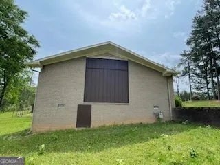 a front view of house with yard and trees in the background
