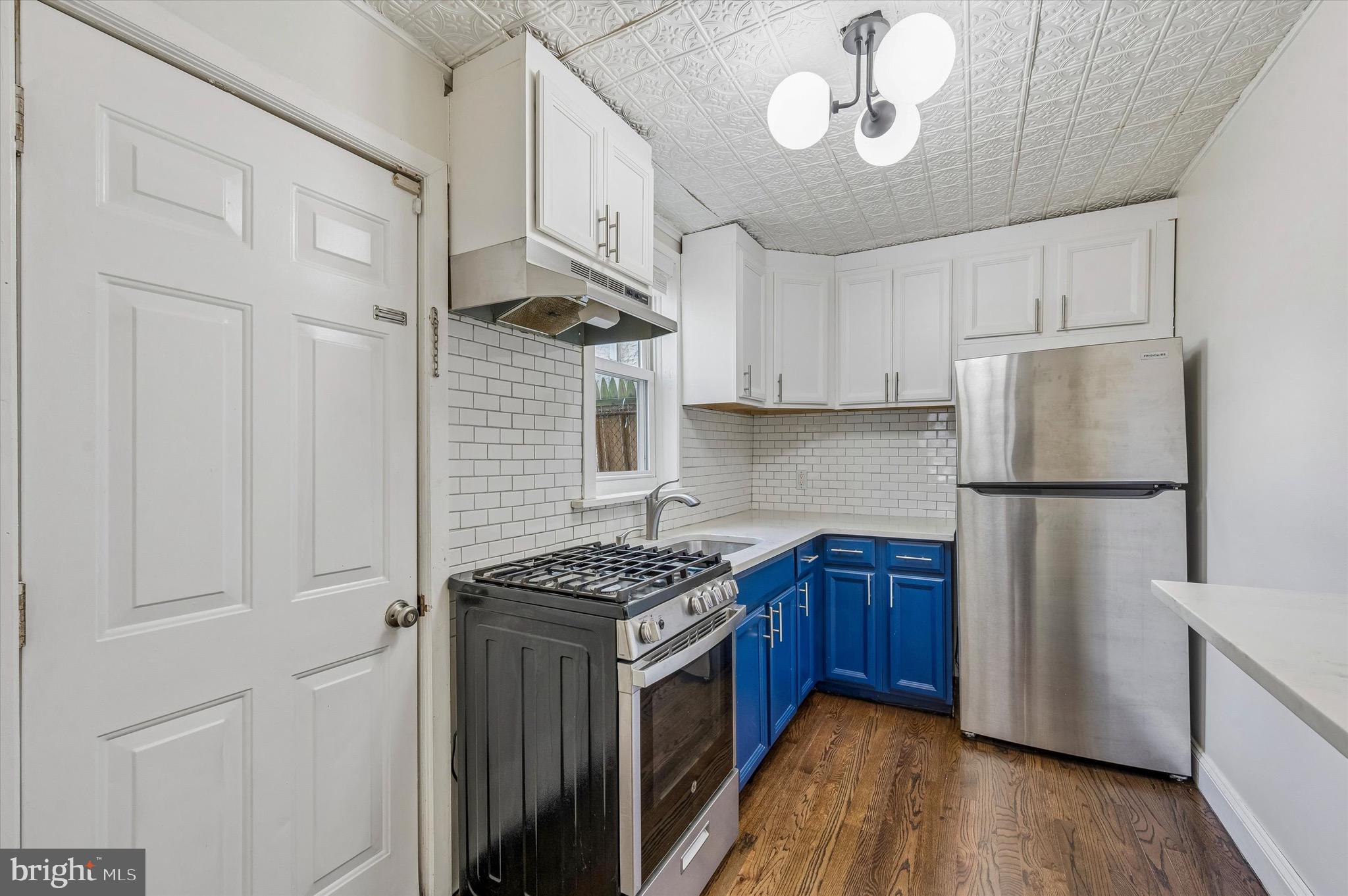 2531 Webb Street Philadelphia, PA 19125 - Photo 8 of 15 a kitchen with stainless steel appliances granite countertop a stove a refrigerator and a sink with wooden cabinets