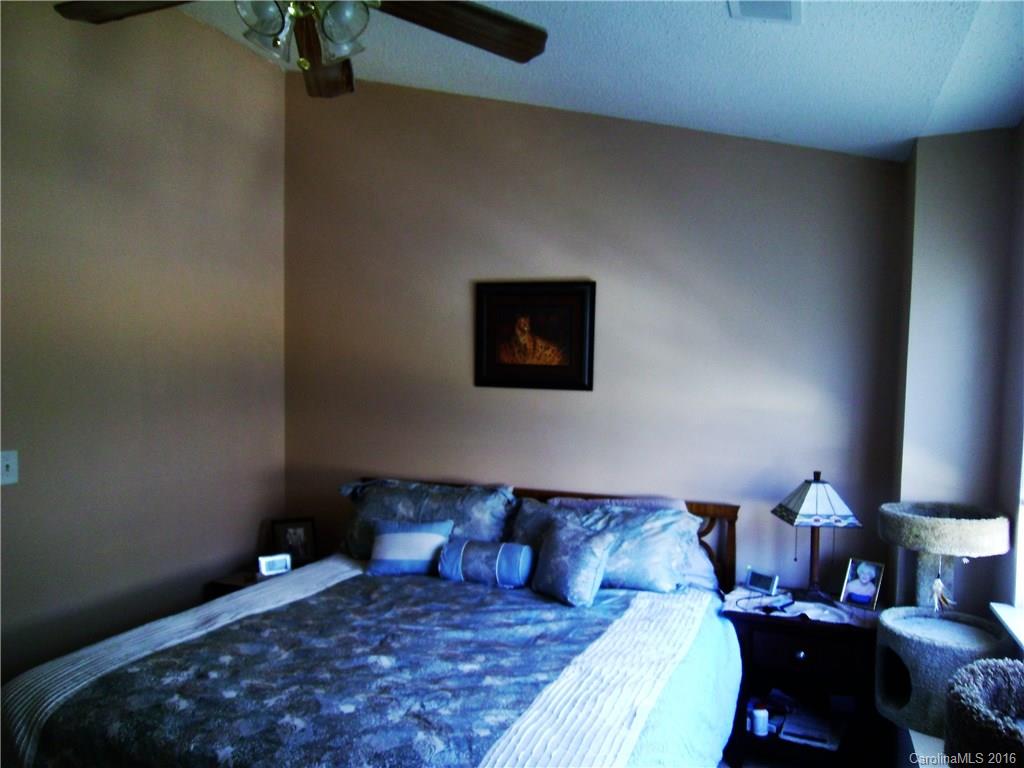 8214 Rudolph Road, Unit 8214 Charlotte, NC 28216 - Photo 14 of 19 a large bed sitting in a bedroom next to a lamp
