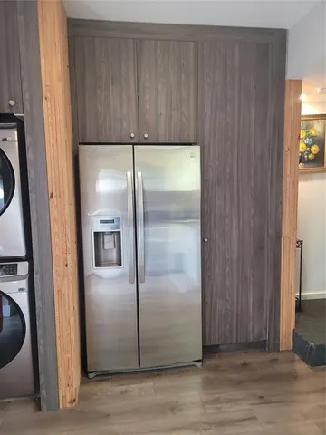 a view of a refrigerator in kitchen and a wooden cabinet