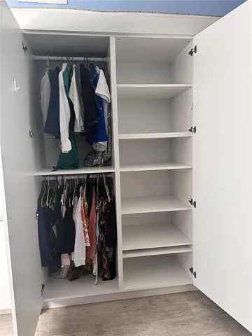 a view of walk in closet with clothes and shoes
