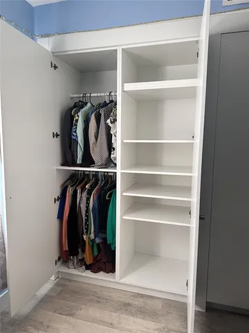 a view of walk in closet with clothes and shoes