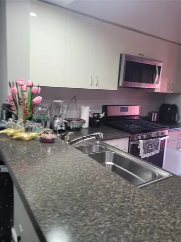 a kitchen with stainless steel appliances granite countertop a sink and a counter top space