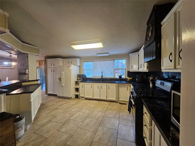 a kitchen with a stove a refrigerator and cabinets