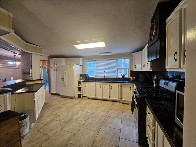 a kitchen with a stove a refrigerator and cabinets