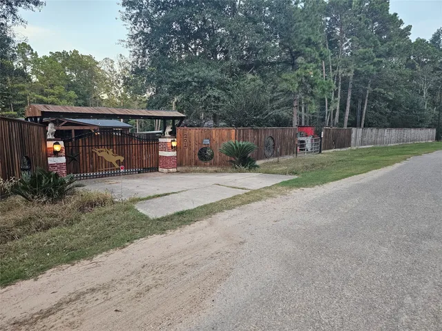 a view of backyard with wooden fence and trees in the background