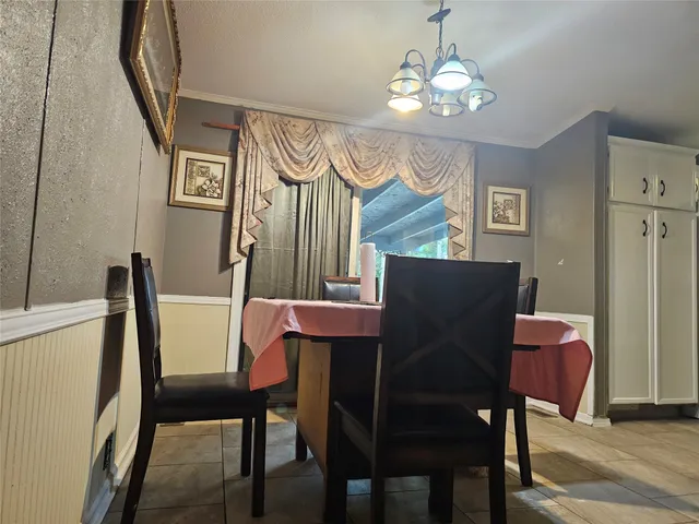 a view of a dining room with furniture and chandelier