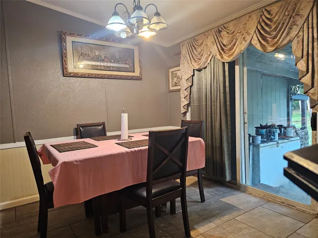 a dining room with wooden floor and chandelier