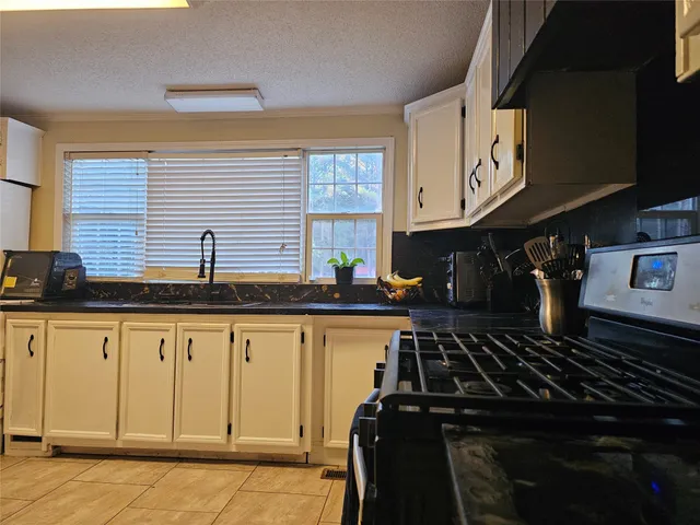 a kitchen with granite countertop a stove and a sink