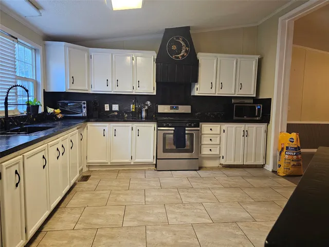 a kitchen with stainless steel appliances a sink a stove a microwave and cabinets