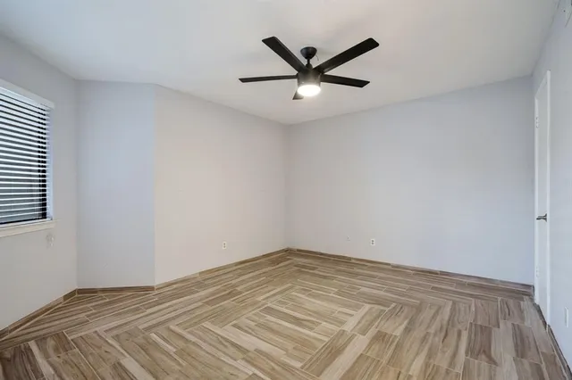 a view of a big room with wooden floor and windows