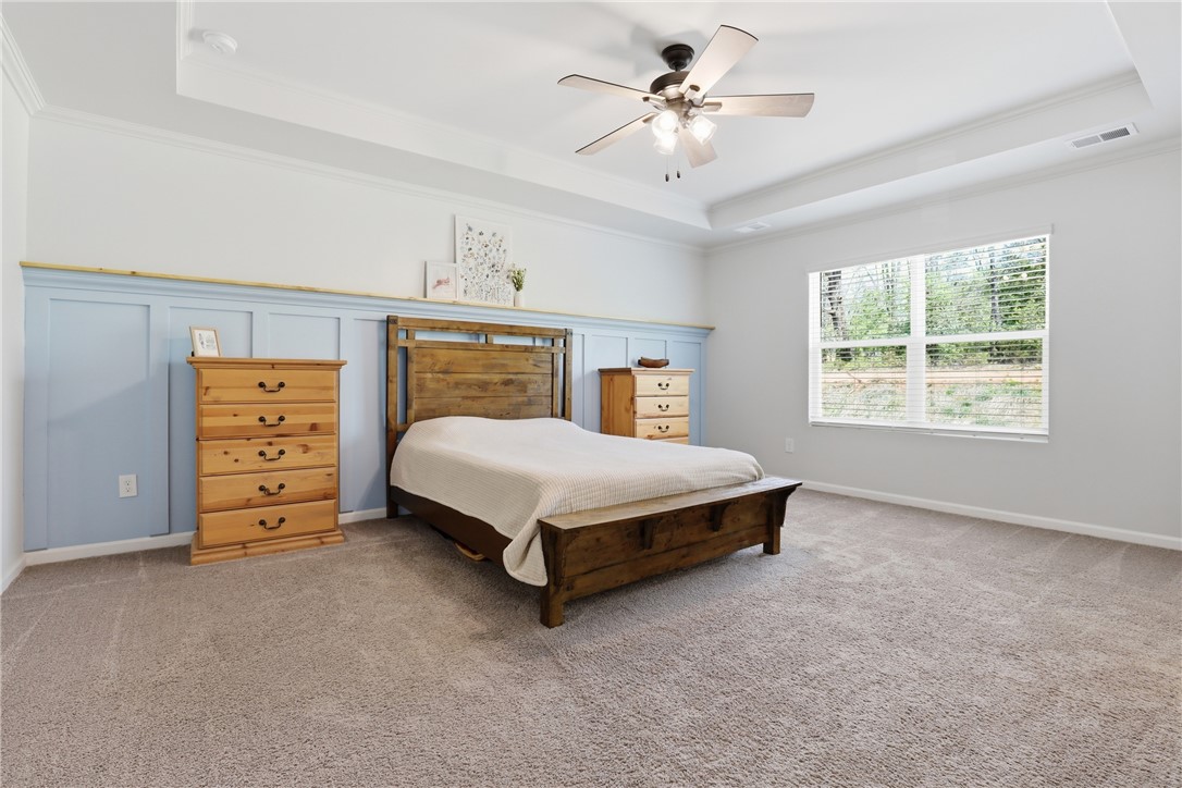 36 Chalet Court Anderson, SC 29621 - Photo 14 of 30 This spacious primary bedroom features carpet flooring and a tray ceiling, offering a comfortable retreat.