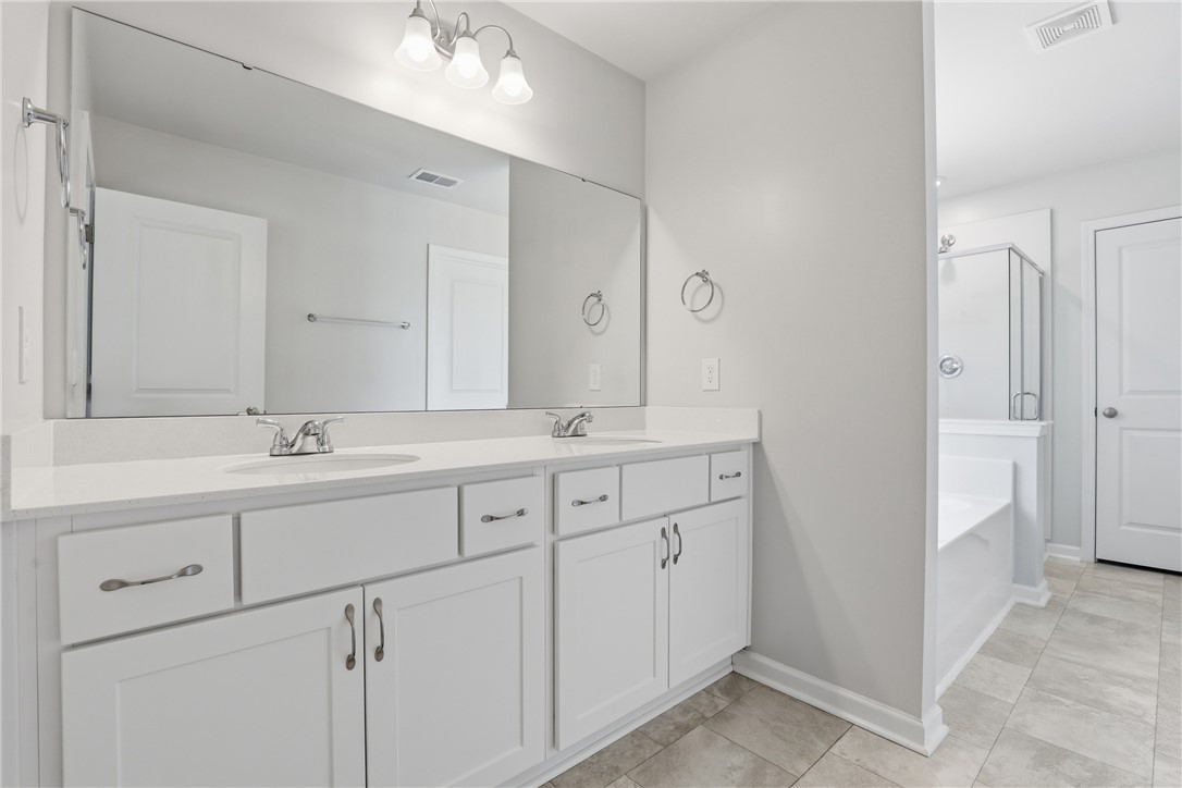 36 Chalet Court Anderson, SC 29621 - Photo 16 of 30 This spacious bathroom offers dual vanities, providing both convenience and ample counter space.