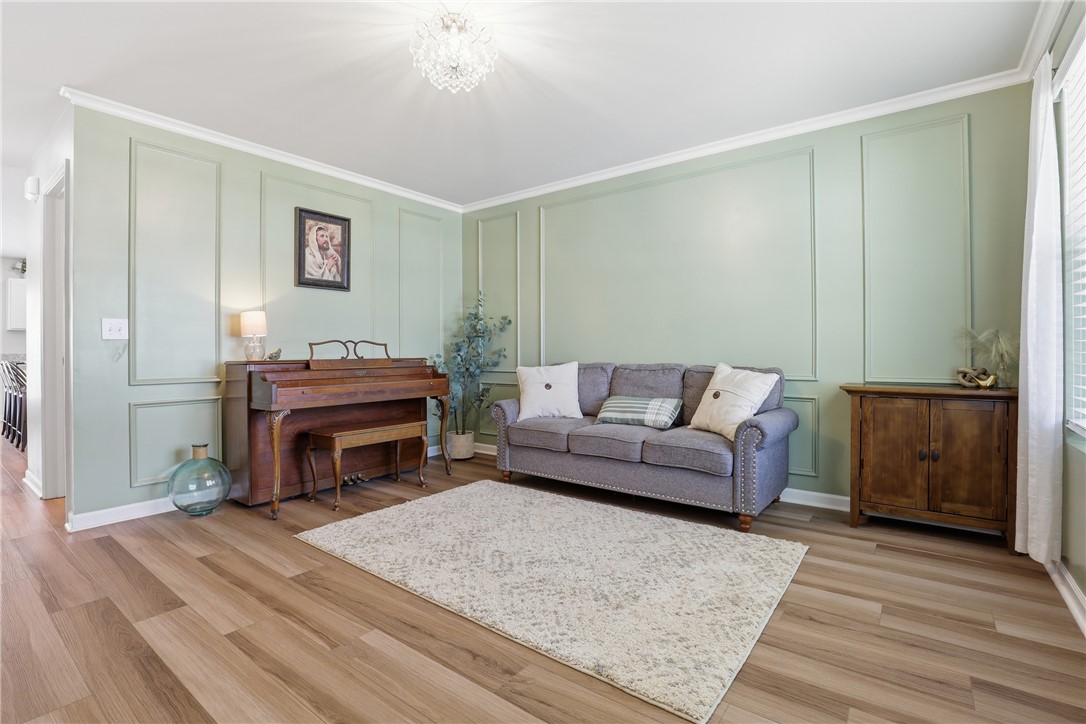 36 Chalet Court Anderson, SC 29621 - Photo 3 of 30 This inviting living space features warm flooring, elegant crown molding, and a stylish decorative wall.