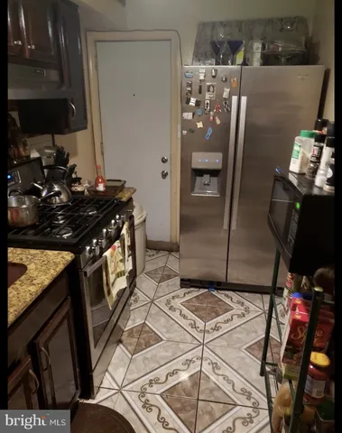 a kitchen with stainless steel appliances granite countertop a refrigerator and a stove