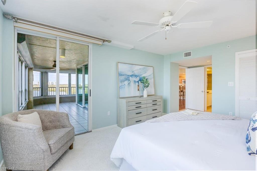 21 Bluebill Avenue, Unit B806 Naples, FL 34108 - Photo 13 of 22 a bedroom with a balcony a bed and a couch