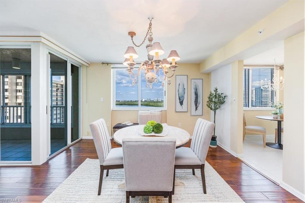 21 Bluebill Avenue, Unit B806 Naples, FL 34108 - Photo 2 of 22 a view of a dining room with furniture wooden floor and chandelier